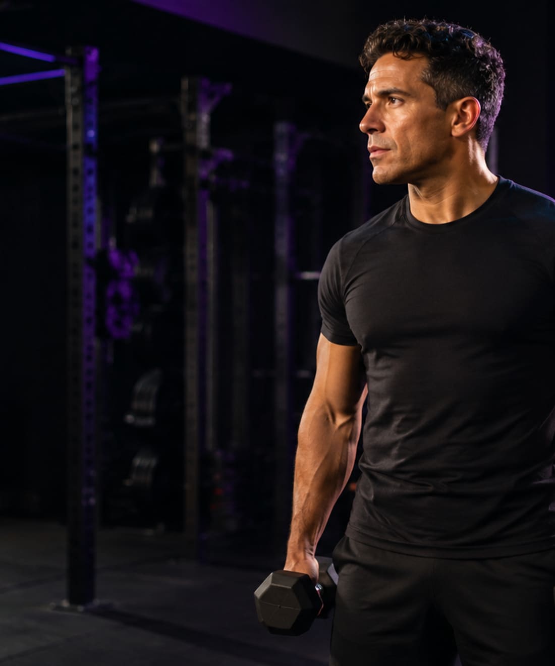 Daniel Alexis Lozano Luévano en el gimnasio, con mancuernas, iluminación editorial oscura.